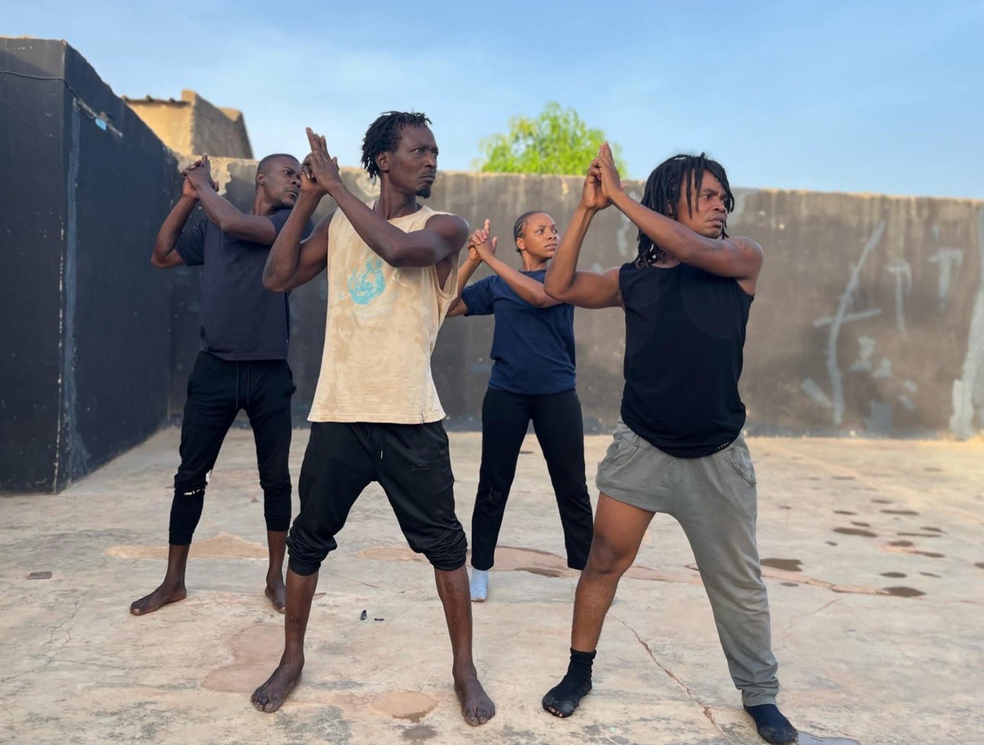 Quatre comédiens de la troupe en répétition dans la cour